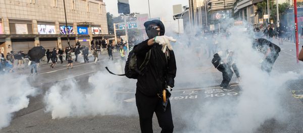 Pro-democracy protesters react after police fired tear gas during a march from the Tsim Sha Tsui district to Hung Hom in Hong Kong on December 1, 2019. - Tens of thousands of black-clad protesters flooded into the streets of Hong Kong on December 1, ending a brief election lull and demanding the government make concessions after pro-democracy candidates won a landslide victory. - Sputnik International