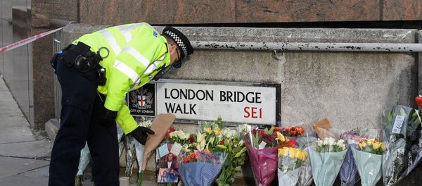 A police officer places a floral tribute near the scene of a stabbing on London Bridge, in London - Sputnik International