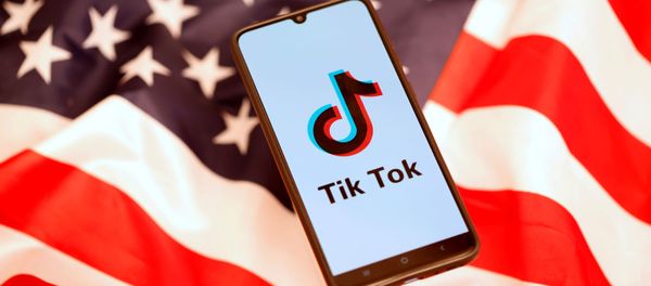 TikTok logo is displayed on the smartphone while standing on the U.S. flag TikTok logo is displayed on the smartphone while standing on the U.S. flag - Sputnik International