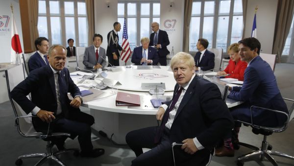 French President Emmanuel Macron, behind right, U.S. President Donald Trump, center behind, Japan's Prime Minister Shinzo Abe, partially hidden second right, Britain's Prime Minister Boris Johnson, right, German Chancellor Angela Merkel , third right, Canada's Prime Minister Justin Trudeau, right, Italy's Prime Minister Giuseppe Conte, left, and European Council President Donald Tusk attend a G7 working session on International Economy and Trade, and International Security Agenda during the G7 summit in Biarritz, southwestern France, Saturday Aug. 25, 2019.  - Sputnik International