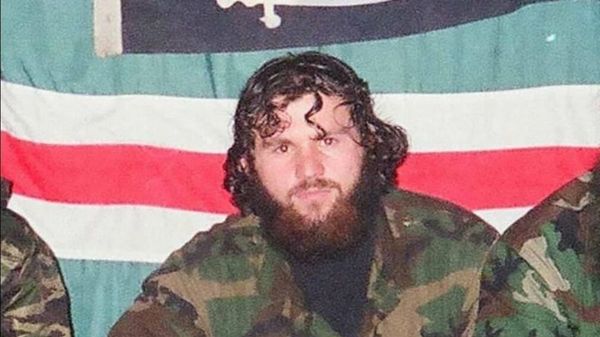 Zelimkhan Khangoshvili is pictured against the backdrop of the flag of the unrecognised Chechen Republic of Ichkeria during the Chechen conflict. - Sputnik International