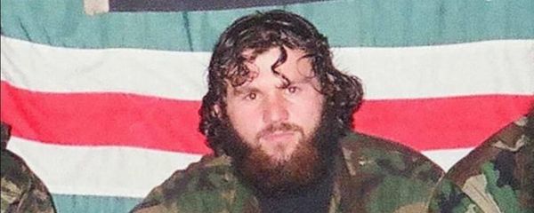 Zelimkhan Khangoshvili is pictured against the backdrop of the flag of the unrecognised Chechen Republic of Ichkeria during the Chechen conflict. - Sputnik International