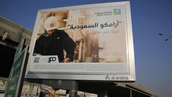 A man walks under a billboard displaying an advertisement for Saudi Arabia's state-owned oil giant Aramco with Arabic reading: Saudi Aramco, soon on stock exchange in Jiddah, Saudi Arabia, Tuesday, Nov. 12, 2019 A man walks under a billboard displaying an advertisement for Saudi Arabia's state-owned oil giant Aramco with Arabic reading: Saudi Aramco, soon on stock exchange in Jiddah, Saudi Arabia, Tuesday, Nov. 12, 2019 - Sputnik International
