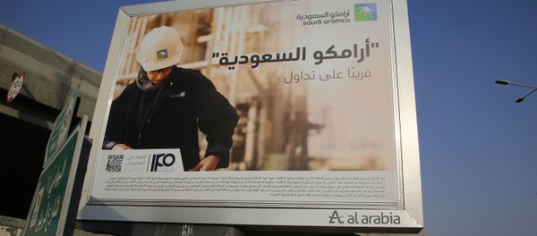 A man walks under a billboard displaying an advertisement for Saudi Arabia's state-owned oil giant Aramco with Arabic reading: Saudi Aramco, soon on stock exchange in Jiddah, Saudi Arabia, Tuesday, Nov. 12, 2019 - Sputnik International