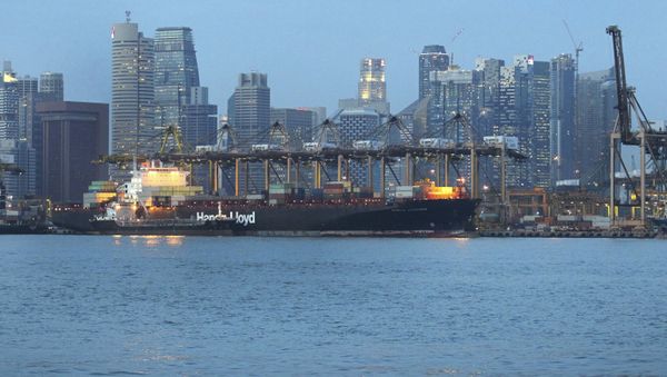 A container ship enters the Singapore ports with the financial skyline in the background on Monday Oct. 22, 2012 in Singapore. Singapore is known to have one of the world's best shipping facilities.  - Sputnik International