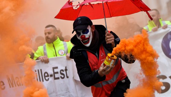 A man wearing a clown mask and waving a smoke bomb takes part in a demonstration to protest against the pension overhauls, in Marseille, southern France, on December 5, 2019 as part of a national general strike. A man wearing a clown mask and waving a smoke bomb takes part in a demonstration to protest against the pension overhauls, in Marseille, southern France, on December 5, 2019 as part of a national general strike. - Sputnik International