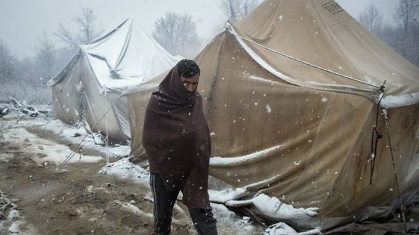 A migrant walks amid tents during snowfall at the Vucjak refugee camp outside Bihac, northwestern Bosnia, Monday, Dec. 2, 2019. - Sputnik International