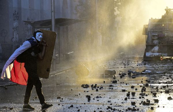 A demonstrator wearing a Guy Fawkes mask and holding a makeshift shield takes part in a protest against the government in Santiago on November 29, 2019. A demonstrator wearing a Guy Fawkes mask and holding a makeshift shield takes part in a protest against the government in Santiago on November 29, 2019. - Sputnik International