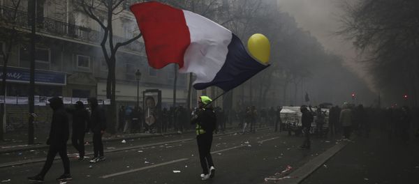 A man waves a French flag during a demonstration in Paris, Thursday, Dec. 5, 2019. Small groups of protesters are smashing store windows, setting fires and hurling flares in eastern Paris amid mass strikes over the government's retirement reform. - Sputnik International