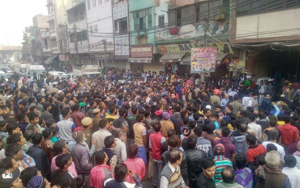People gather on the street as a massive blaze breaks out at a factory in New Delhi's Anaj Mandi district People gather on the street as a massive blaze breaks out at a factory in New Delhi's Anaj Mandi district - Sputnik International
