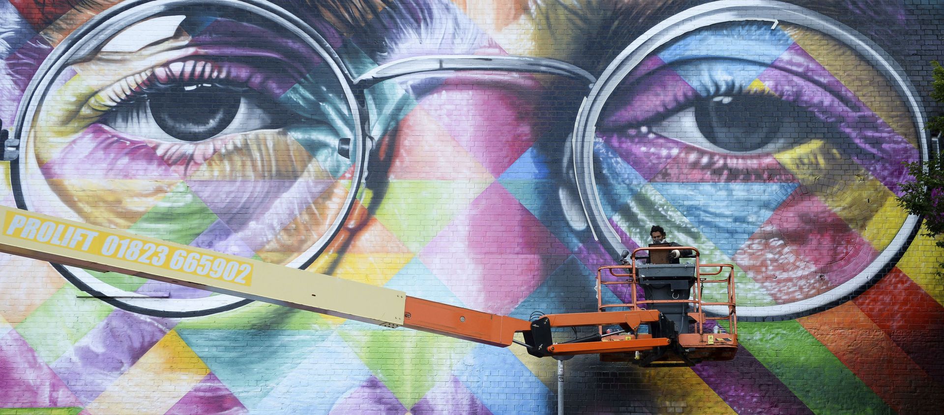 A graffiti artist works on a huge mural of former Beatle John Lennon A graffiti artist works on a huge mural of former Beatle John Lennon - Sputnik International, 1920, 08.12.2019