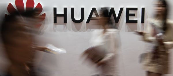 (FILES) In this file photo taken on August 2, 2019 people walk past a Huawei logo during the Consumer Electronics Expo in Beijing. - Chinese tech giant Huawei, facing US criminal charges and economic sanctions, is planning to relocate its telecommunications research from the United States to Canada, founder Ren Zhengfei said in an interview published on December 3, 2019 - Sputnik International