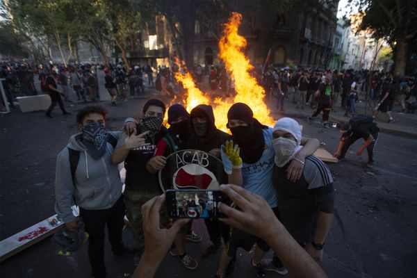 Demonstrators pose for a picture near a bonfire at a blocked street during a protest against the government of Chilean President Sebastian Pinera, in Santiago, on December 06, 2019 Demonstrators pose for a picture near a bonfire at a blocked street during a protest against the government of Chilean President Sebastian Pinera, in Santiago, on December 06, 2019 - Sputnik International