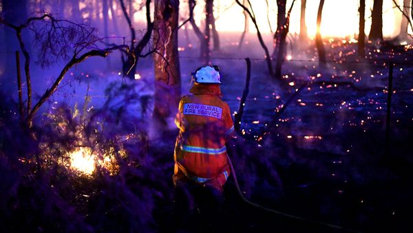 This photo taken on December 7, 2019 shows a firefighter conducting backburning measures to secure residential areas from encroaching bushfires at the Mangrove area, some 90-110 kilometres north of Sydney - Sputnik International