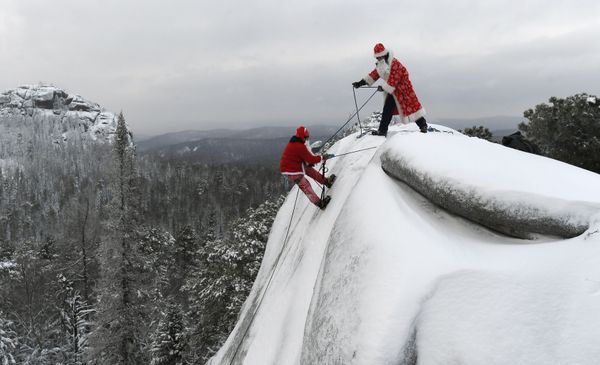 Mikhail Morin, a member of the search and rescue squad Rescuer, dressed as Santa Claus, left, and Dmitry Ivanov participate in the final rock training of the year on the syenite rock Fourth Pillar in Stolby Nature Sanctuary outside the Siberian city of Krasnoyarsk, Russia Mikhail Morin, a member of the search and rescue squad Rescuer, dressed as Santa Claus, left, and Dmitry Ivanov participate in the final rock training of the year on the syenite rock Fourth Pillar in Stolby Nature Sanctuary outside the Siberian city of Krasnoyarsk, Russia - Sputnik International