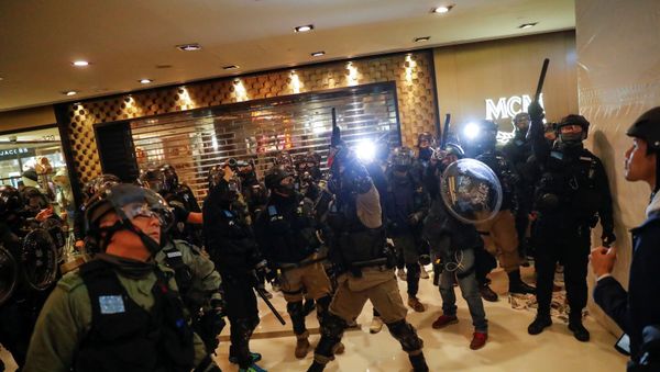 A police officer aims his weapon during an anti-government protest inside a mall, in Hong Kong, China December 15, 2019 - Sputnik International
