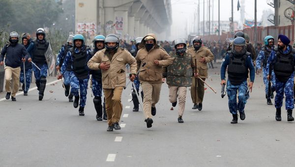 Policemen are chased by demonstrators during a protest against the new citizenship law in Seelampur, an area of Delhi, India on 17 December 2019. - Sputnik International