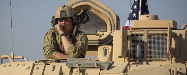 A U.S. soldier observes form the top of a fighting vehicle at a US military base at undisclosed location in Northeastern Syria - Sputnik International