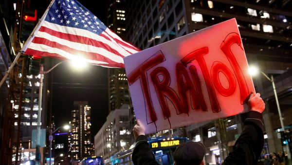 A man holds a sign reading traitor in front of an American flag as protesters take part in a rally to support the impeachment and removal of U.S. President Donald Trump outside the federal building in Seattle, Washington, U.S. December 17, 2019 A man holds a sign reading traitor in front of an American flag as protesters take part in a rally to support the impeachment and removal of U.S. President Donald Trump outside the federal building in Seattle, Washington, U.S. December 17, 2019 - Sputnik International