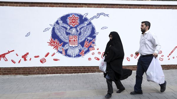 People walk past a satirical drawing of the Great Seal of the United States after new anti-U.S. murals on the walls of former U.S. embassy unveiled in a ceremony in Tehran, Iran, Saturday, Nov. 2, 2019 People walk past a satirical drawing of the Great Seal of the United States after new anti-U.S. murals on the walls of former U.S. embassy unveiled in a ceremony in Tehran, Iran, Saturday, Nov. 2, 2019 - Sputnik International