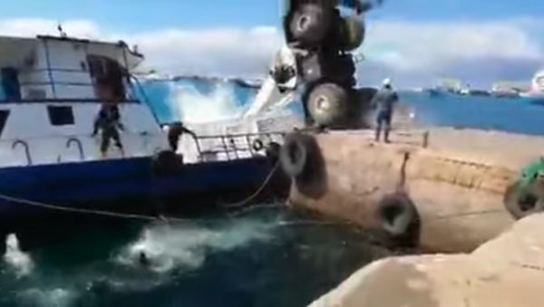 A crane carrying a diesel generator plunges onto the boat it was loading on San Cristobal in Ecuador's Galapagos Islands on December 22, 2019 - Sputnik International