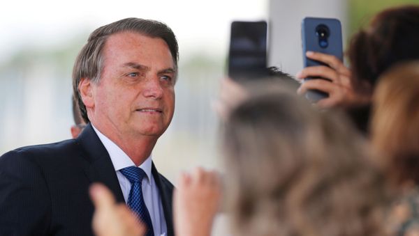 Brazil's President Jair Bolsonaro poses for pictures as he leaves the Alvorada Palace in Brasilia, Brazil December 12, 2019 - Sputnik International