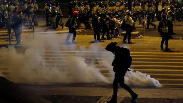 An anti-government demonstrator walks past tear gas on Christmas Eve in Hong Kong, China, December 24, 2019. - Sputnik International
