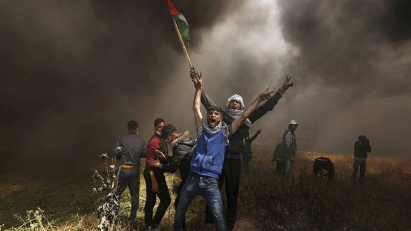Palestinian demonstrators shout during clashes with Israeli troops at a protest demanding the right to return to their homeland, at the Israel-Gaza border east of Gaza City April 6, 2018. - Sputnik International