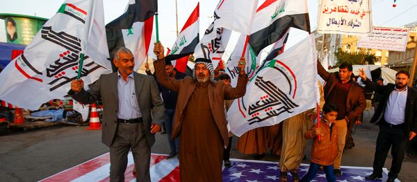 Iraqi people walk on a U.S. flag in a protest after an airstrike at the headquarters of Kataib Hezbollah militia group in Qaim, in the holy city of Najaf, Iraq December 30, 2019. Iraqi people walk on a U.S. flag in a protest after an airstrike at the headquarters of Kataib Hezbollah militia group in Qaim, in the holy city of Najaf, Iraq December 30, 2019. - Sputnik International