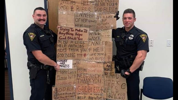 Mobile Alabama Police Department officers seen holding homeless quilt made out of signs confiscated from panhandlers Mobile Alabama Police Department officers seen holding homeless quilt made out of signs confiscated from panhandlers - Sputnik International