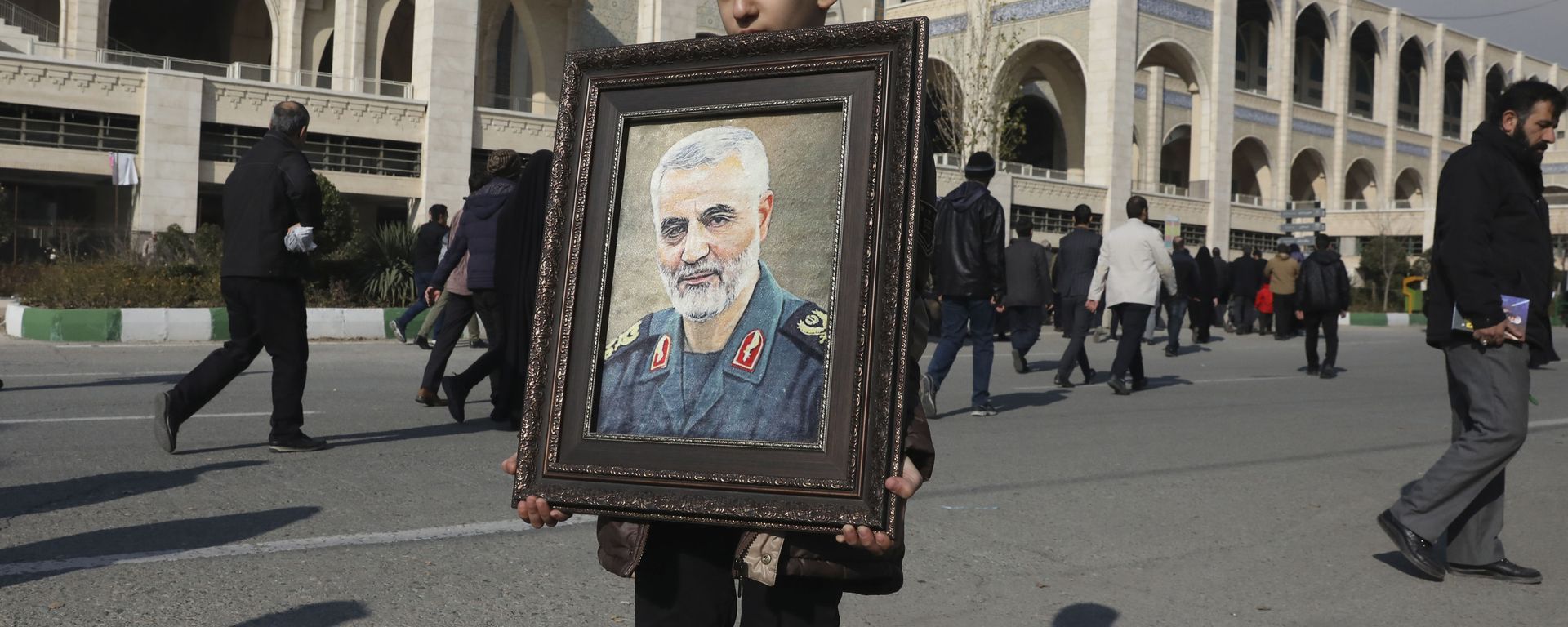 A boy carries a portrait of Iranian Revolutionary Guard Gen. Qassem Soleimani A boy carries a portrait of Iranian Revolutionary Guard Gen. Qassem Soleimani - Sputnik International, 1920, 03.01.2022