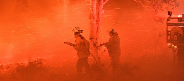 This picture taken on December 31, 2019 shows firefighters struggling against strong winds and flying embers in an effort to secure nearby houses from bushfires near the town of Nowra in the Australian state of New South Wales. This picture taken on December 31, 2019 shows firefighters struggling against strong winds and flying embers in an effort to secure nearby houses from bushfires near the town of Nowra in the Australian state of New South Wales. - Sputnik International