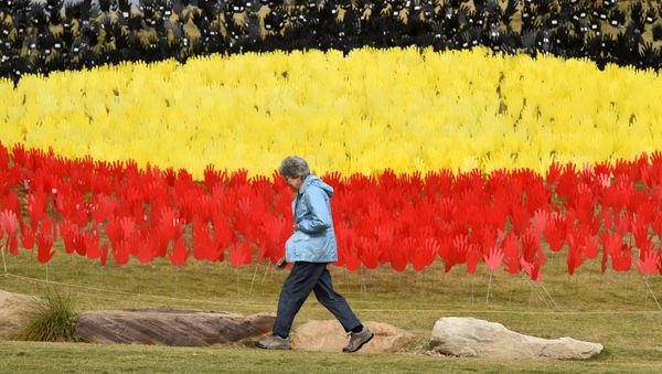 A woman passes a huge art installation called 'Sea of Hands' which consists of thousands of hands in the colours of the Aboriginal flag – red, yellow, black. - Part of National Reconciliation Week 2016, the installation is for Australians to reflect on Australia’s national identity and the place of Aboriginal and Torres Strait Islander histories and cultures in the nation’s story.  - Sputnik International