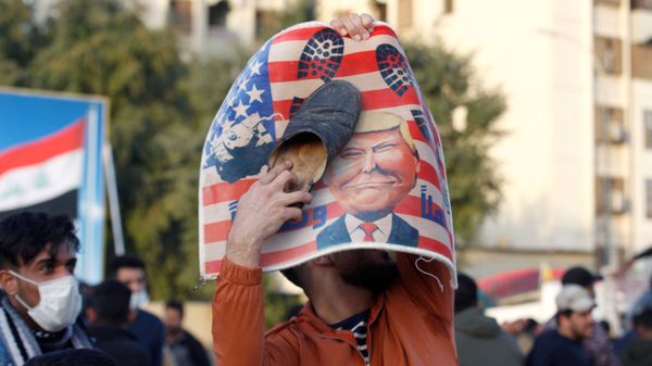 A protester places a shoe at a placard with U.S. President Donald Trump illustration outside the U.S. Embassy during a protest to condemn air strikes on bases belonging to Hashd al-Shaabi (paramilitary forces), in Baghdad, Iraq January 1, 2020. - Sputnik International