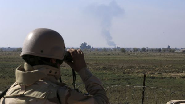 In this Tuesday, Nov. 13, 2018 photo, an Iraqi soldier watches smoke rising after an airstrike by US-led International coalition warplanes against ISIS, on the border between Syria and Iraq in Qaim, Anbar province, Iraq. - Sputnik International
