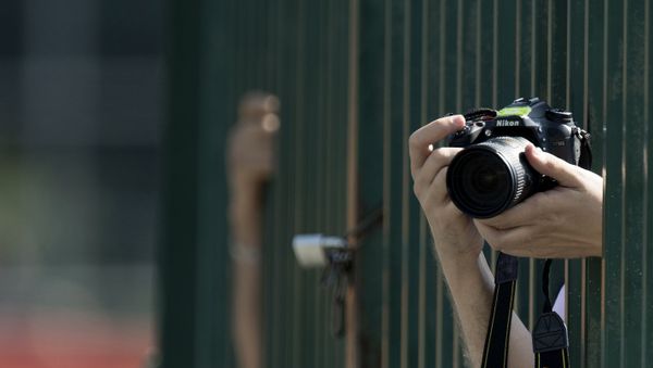 A photographer takes pictures with a Nikon D7100 camera during the third practice session at the Spa-Francorchamps circuit in Spa on August 27, 2016 ahead of the Belgian Formula One Grand Prix - Sputnik International