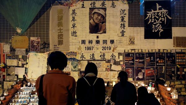 People gather near a makeshift memorial as they pay tribute to Chow Tsz-lok, 22, a university student who died two months ago after he fell from a car park during a protest, at Tseung Kwan O district in Hong Kong, China, January 8, 2020 People gather near a makeshift memorial as they pay tribute to Chow Tsz-lok, 22, a university student who died two months ago after he fell from a car park during a protest, at Tseung Kwan O district in Hong Kong, China, January 8, 2020 - Sputnik International