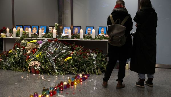 Two women mourn standing in front of a memorial for the flight crew of the Ukrainian 737-800 plane that crashed on the outskirts of Tehran, inside Borispil international airport outside Kyiv, Ukraine, late Wednesday, Jan. 8, 2020 - Sputnik International