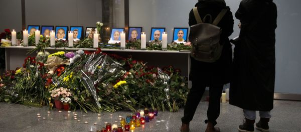 Two women mourn standing in front of a memorial for the flight crew of the Ukrainian 737-800 plane that crashed on the outskirts of Tehran, inside Borispil international airport outside Kyiv, Ukraine, late Wednesday, Jan. 8, 2020 - Sputnik International