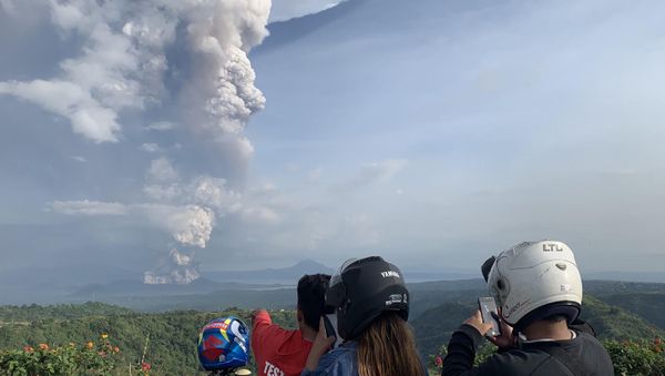 People take photos of a phreatic explosion from the Taal volcano as seen from the town of Tagaytay in Cavite province, southwest of Manila, on January 12, 2020. - Sputnik International