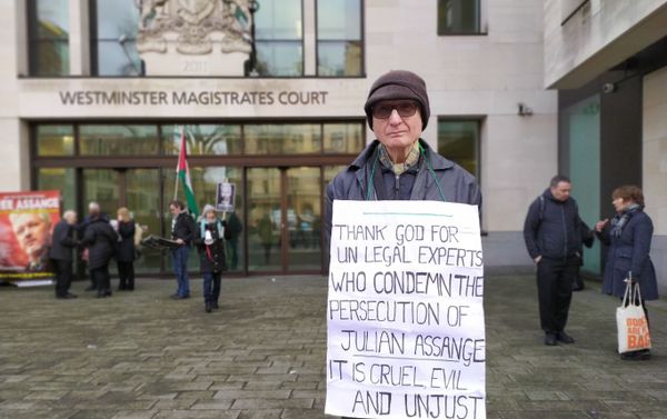 Man stand silently outside Westminster Mags with banner condemning treatment of Julian Assange - Sputnik International