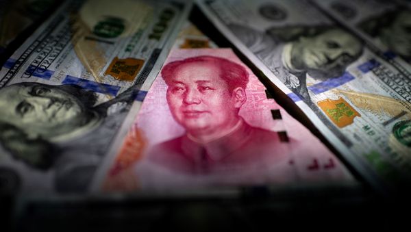 This photo illustration shows a Chinese 100 yuan note (C) and US 100 notes in Beijing on January 14, 2020 This photo illustration shows a Chinese 100 yuan note (C) and US 100 notes in Beijing on January 14, 2020 - Sputnik International