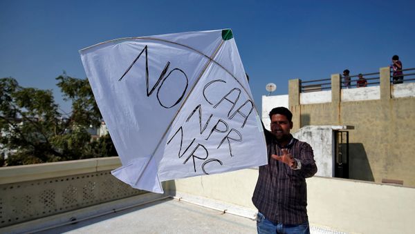 A man tries to fly a kite with a message, as part of a protest against a new citizenship law, on the occasion of kite flying festival, locally known as Uttarayan, in Ahmedabad, India, January 14, 2020 A man tries to fly a kite with a message, as part of a protest against a new citizenship law, on the occasion of kite flying festival, locally known as Uttarayan, in Ahmedabad, India, January 14, 2020 - Sputnik International