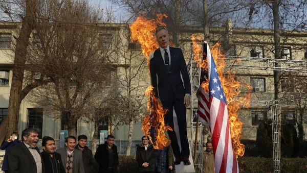 Pro-government protesters set fire to U.S. and British flags with a life size cut-out of Britain's ambassador to Tehran Rob Macaire, in a gathering to commemorate the late Iranian Gen. Qassem Soleimani, who was killed in Iraq in a U.S. drone attack on Jan. 3, and victims of last week's Ukrainian plane crash outside Tehran, at the Tehran University campus in Tehran, Iran, Tuesday, Jan. 14, 2020 - Sputnik International