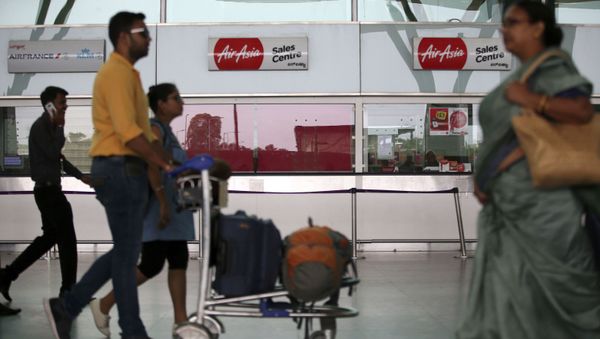 Passengers walk past the sales centre of AirAsia at Kempegowda International Airport in Bangalore, India, Wednesday, May 30, 2018 - Sputnik International