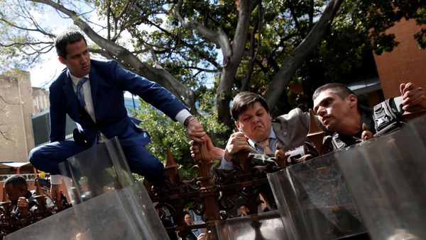 Venezuelan opposition leader Juan Guaido, who many nations have recognised as the country's rightful interim ruler, and other lawmakers climb on the fence of Venezuela's National Assembly building in Caracas, Venezuela January 5, 2020 - Sputnik International