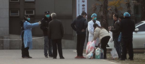 Medical staff and security personnel stop patients' family members from getting too close to the Jinyintan hospital, where patients with pneumonia caused by the new strain of coronavirus are being treated, in Wuhan, Hubei province, China, 20 January 2020 - Sputnik International