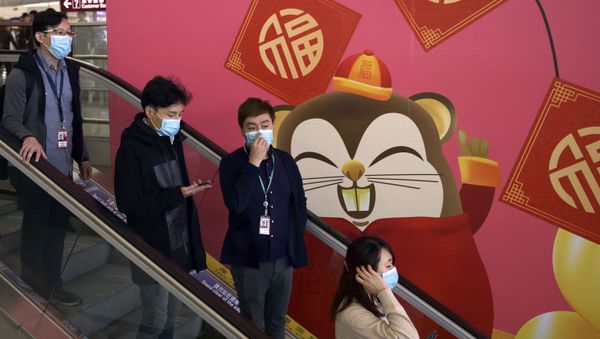 People wear face masks as they ride an escalator at the Hong Kong International Airport in Hong Kong, Tuesday, Jan. 21, 2020 - Sputnik International