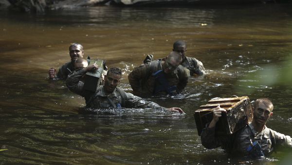 U.S. Army Soldiers assigned to Bravo Co. 3rd Battalion, 7th Infantry Regiment, 2nd Infantry Brigade Combat Team, 3rd Infantry Division carry equipment through a pond during the team obstacle course at the French Jungle Warfare School near Yemen, Gabon, June 9, 2016. - Sputnik International