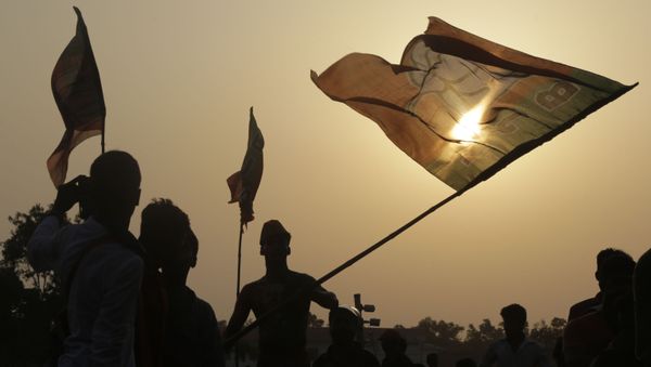 Supporters of India's ruling Bharatiya Janata Party (BJP) cheer with party flags as they attend an election rally addressed by Indian Prime Minister Narendra Modi, in Mathurapur, south of Kolkata, India, Thursday, May 16, 2019.  - Sputnik International